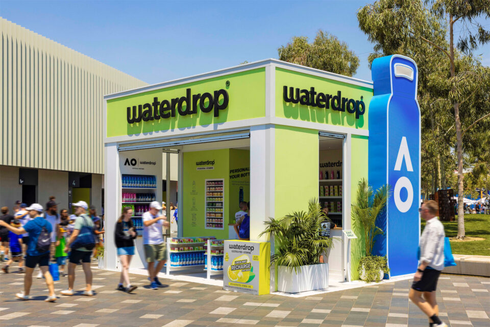 a Waterdrop branded temporary event building with people walking past