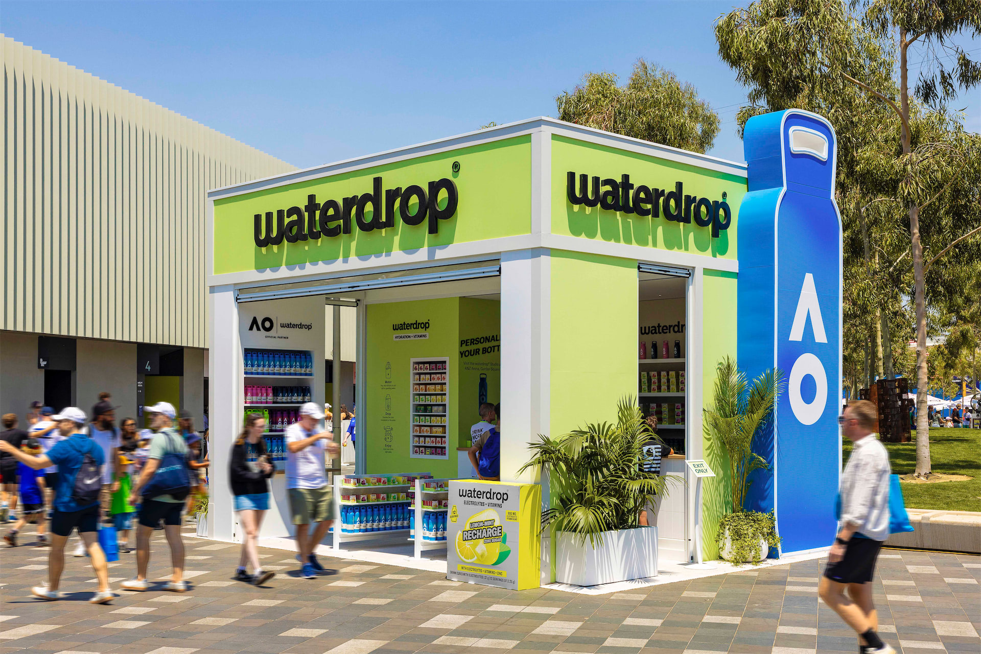 a Waterdrop branded temporary event building with people walking past