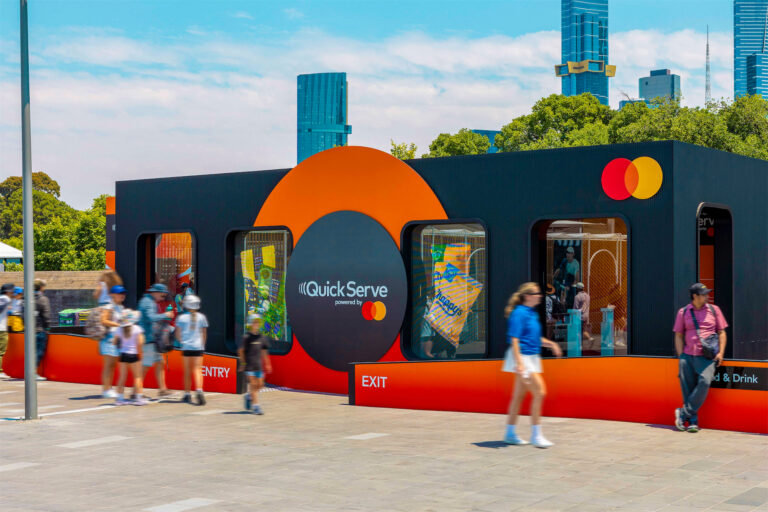a group of people walking past a Mastercard store. Modular brand activation structure using Groblox