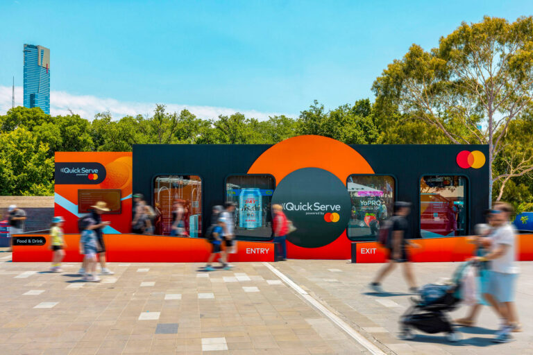 A group of people walking past a modular brand activation structure built with Groblox